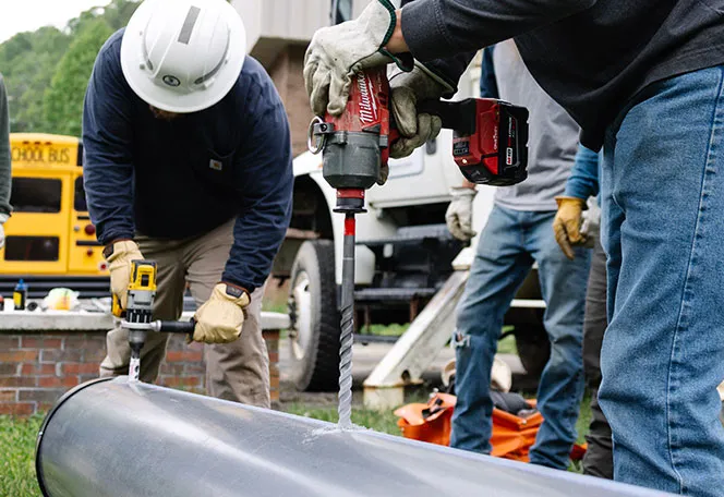 Milwaukee Drill drilling in utility pole